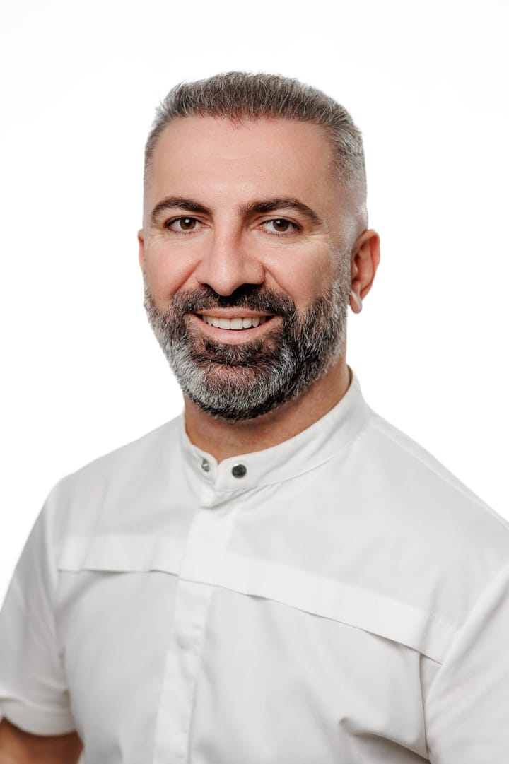 Portrait of Dr Elchin Abbasov in a white clinical tunic